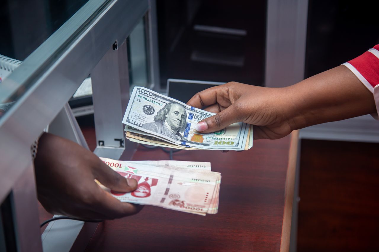 services-03 Hands exchanging US and local currency at a bank counter, signifying international finance.